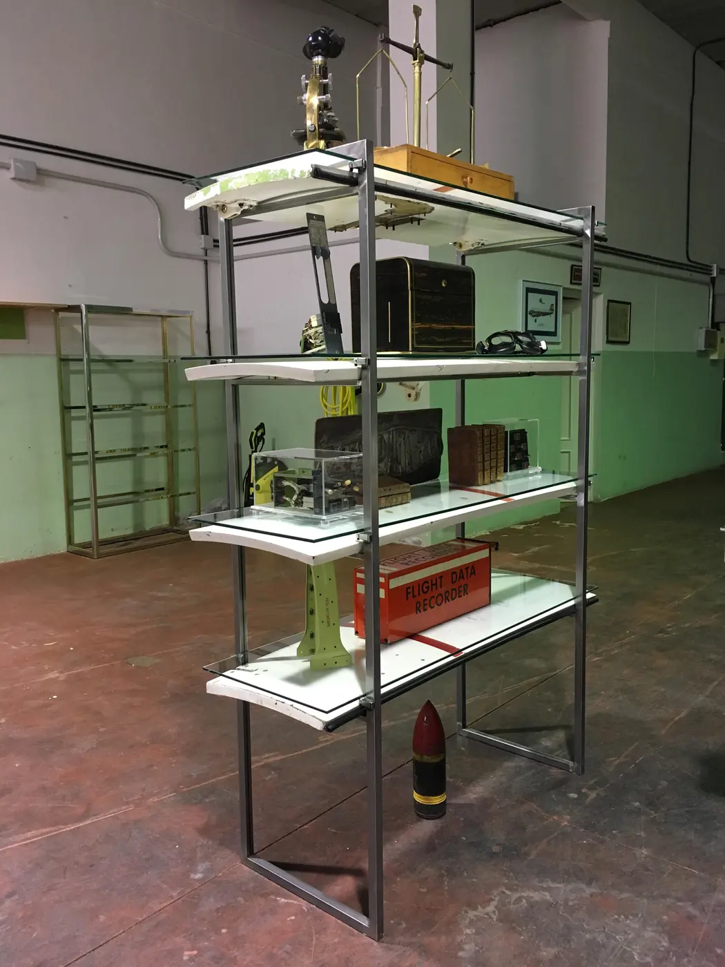 Estantería hecha con compuertas de tren de aterrizaje, con instrumentos de vuelo y una caja negra Flight Data Recorder naranja